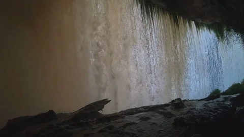 A walk behind a waterfall at sunset with strong winds Stock Footage 146326504
