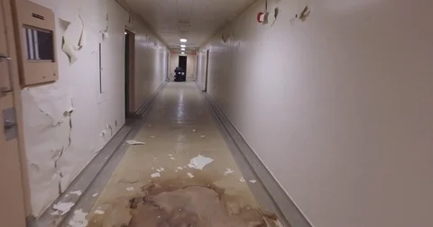 Walk down hallway in abandoned building towards barrels Stock Footage 72296108