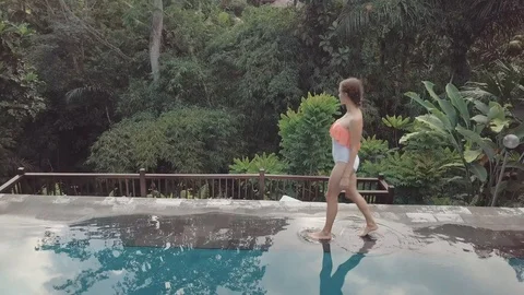 Walk on the edge of the pool with the jungle view aerial footage Stock Footage 100273704
