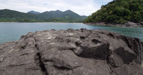 Walk over top of small black lava islet, looking to Juara Bay and Tioman island Stock Footage 314770350