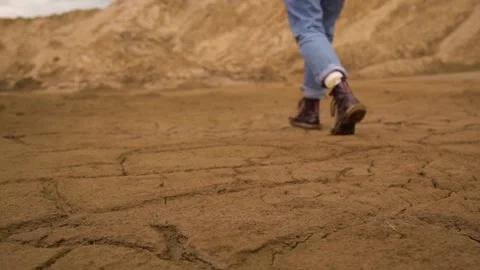 Walk in red boots on dry ground in cracks. 1920x1080. full hd. slow motion. Stock-Footage 130652247