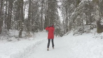 Walk in the snowy part in the winter time girl in the red jacket winter time Stock Footage 86087964
