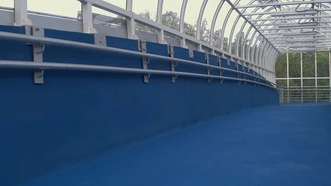 Walk through covered pedestrian bridge above road traffic. Stock Footage 109552722