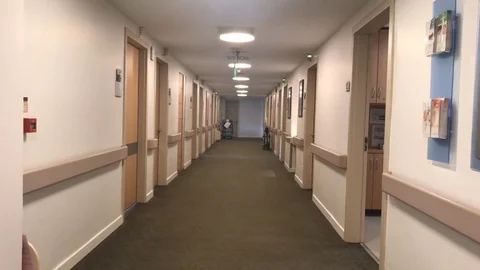 Walk through long, empty medical center building corridor Stock Footage 83397104