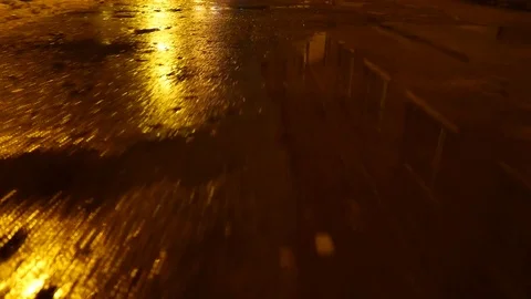Walk through puddles on the pavement in the night. 4K UHD Vídeo Stock 69715084