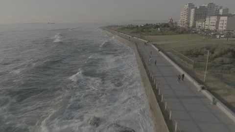 Walk way next to the beach with waves crashing into the coast Stock Footage 318069745