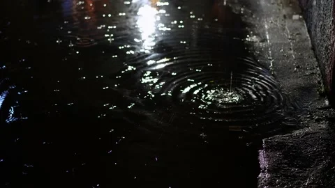 Walker avoiding puddles on a rainy night Stock Footage