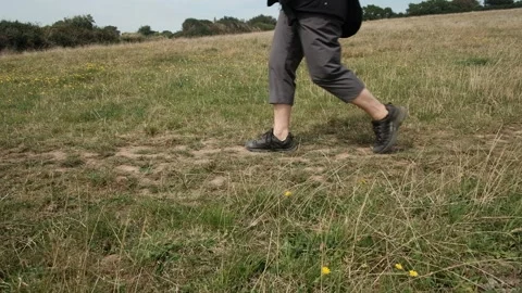 A walker in the countryside hiking on a grassy path, female middle aged. Stock Footage 286390630