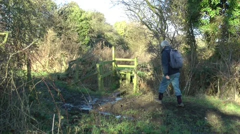 Walker on public right of way footpath crossing a stile rural setting Stock Footage 46447019