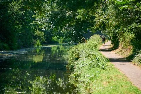 A walker strolling down a canal Stock Photos