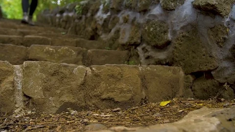 Walker walking down old stone steps Stock Footage 80484248