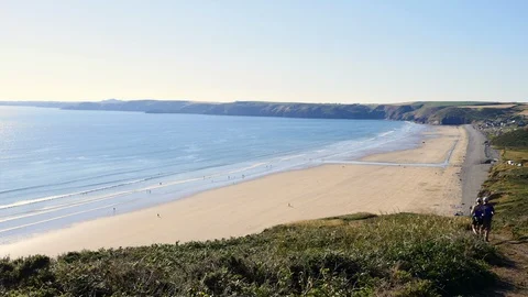 Walkers on the coast path over looking Newgale and St Brides Bay Stock Footage 93858946