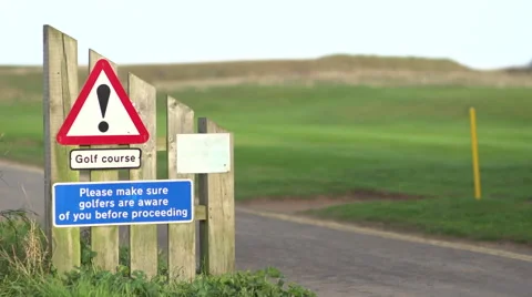 Walkers crossing a golf course with warning sign - half speed Stock Footage 63458675