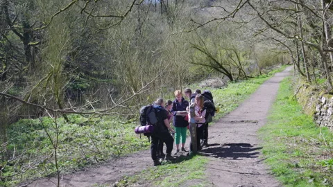 Walkers studying maps by the the River Wye at Chee Dale Stock Footage 308757351