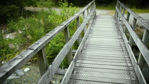 Walking across bridge, looking down the river, mountain in the distance. Stock Footage 260775815