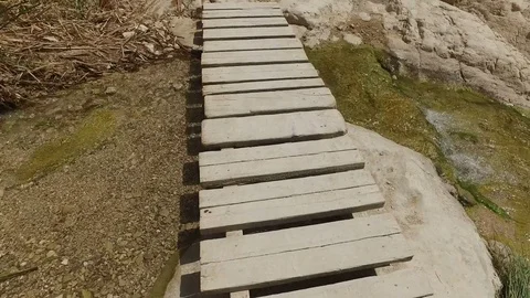 Walking Across Bridge Over Desert Stream Stock Footage 77878757