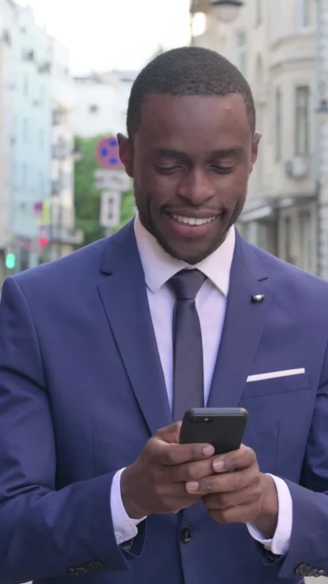 Walking African Businessman Browsing Internet on Smartphone, Vertical Video Stock Footage 340029054
