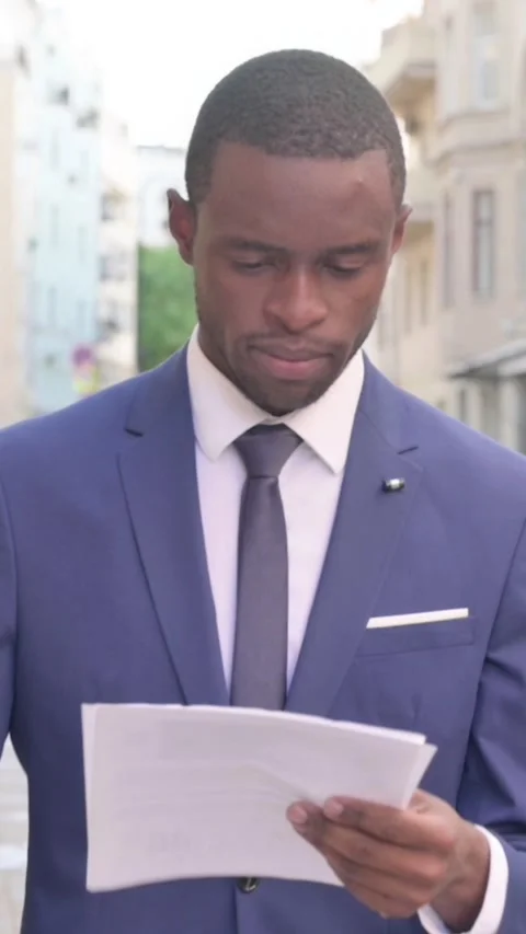 Walking African Businessman Reading Document on the Street, Vertical Video Stock Footage 340031986