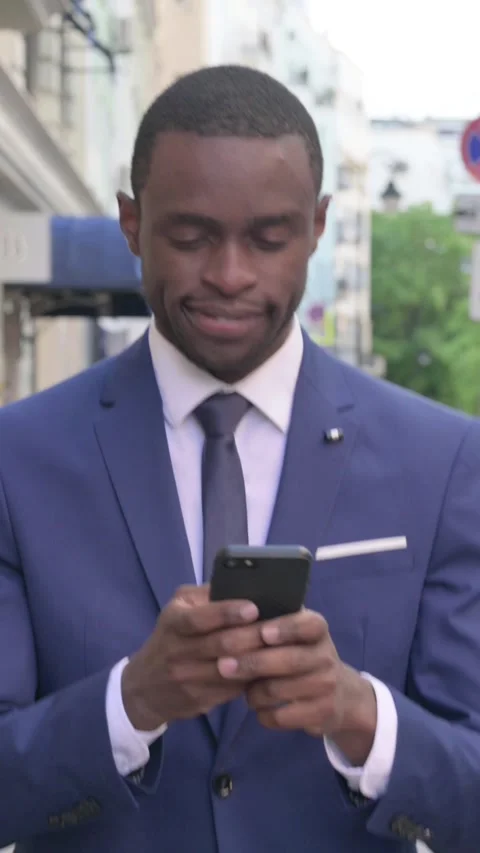 Walking African Businessman using Smartphone, Vertical Video Stock Footage 340028980