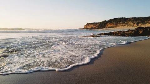 Walking along a beautiful sandy beach with waves washing into the shore. Stock Footage 101769336