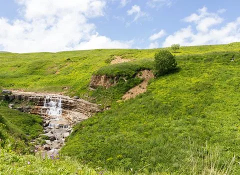 Walking along the bed of a mountain river in a natural park, during the flowe Foto stock