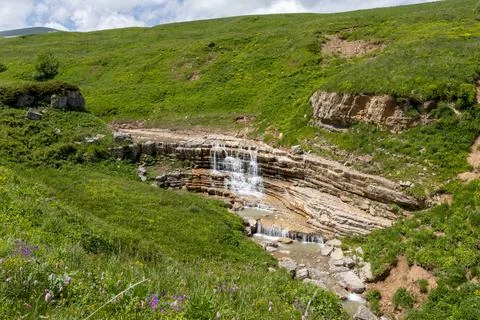 Walking along the bed of a mountain river in a natural park, during the flowe Stock Photos