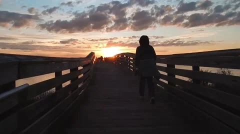 Walking along a bridge at sunset Vídeos de archivo 48014189