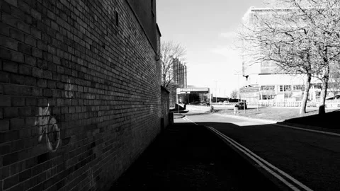 Walking along next to a red brick wall in an industrial part of town Video stock 171800227
