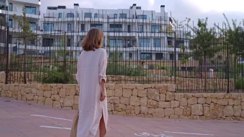 Walking along the path near modern buildings in the late afternoon Vídeos de archivo 346017519