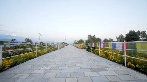 Walking along path with prayer flags and flowers on either side in Nepal Video stock 91166220