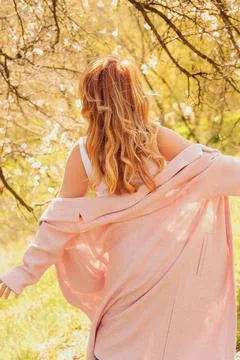 Walking along  path under trees with blossoms on  sunny day in spring.  perso Stock Photos