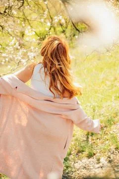 Walking along  path under trees with blossoms on  sunny day in spring.  perso Stock Photos