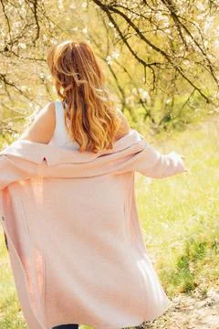 Walking along  path under trees with blossoms on  sunny day in spring.  perso Stock Photos