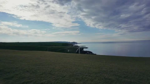 Walking along quiet pebble beach with sea groynes and coastal cliffs Stock Footage 309767727