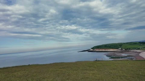 Walking along quiet pebble beach with sea groynes and coastal cliffs Stock Footage 309767729