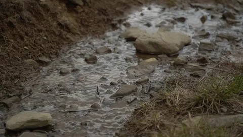 Walking along a rocky path with flowing water in a mountainous area Video stock 328095297