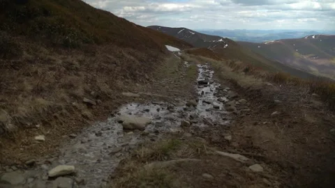 Walking along a rocky path with flowing water in a mountainous area 库存影片 330660501