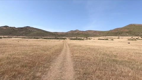 Walking along a rural path towards a hill Stock Footage 271244326