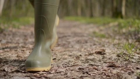 Walking along a scenic Leafy Path while wearing Rubber Boots on a beautiful Stock Footage 306307741