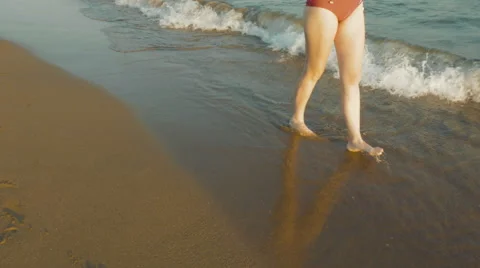 Walking alongside the waves at the beach Stock Footage 65559496