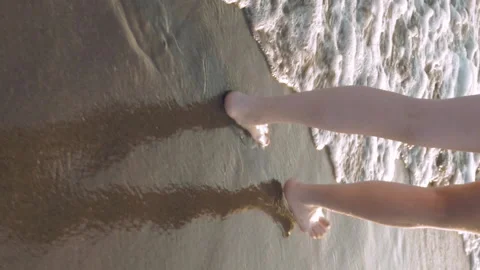 Walking alongside the waves at the beach Stock Footage 91183945
