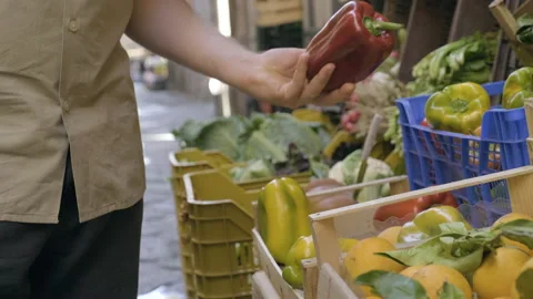 Walking and grabs red pepper in outdoor veggie market Stock Footage 169469035