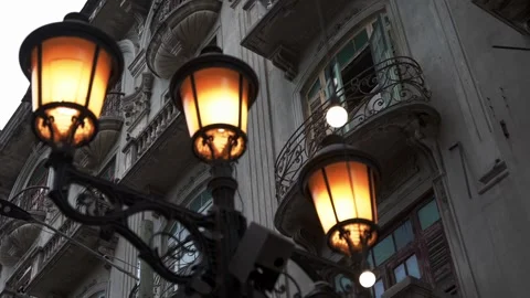 Walking and looking up through illuminated street lamp to the facade of old Stock Footage 274833475