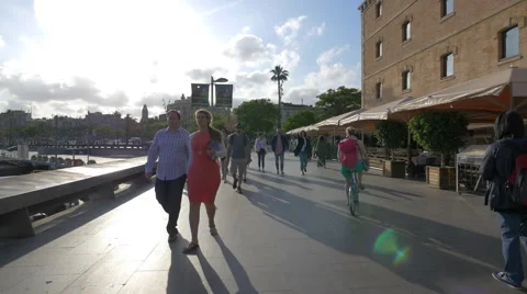 Walking and riding bicycles on the seafront in Barcelona Stock Footage 52057062
