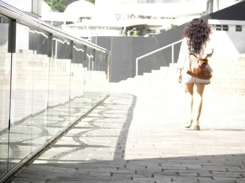 Walking away from camera into white light past a glass barrier Stock Photos