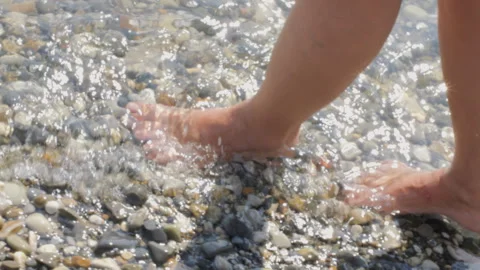 Walking barefoot on pebble beach Stock Footage 286658517