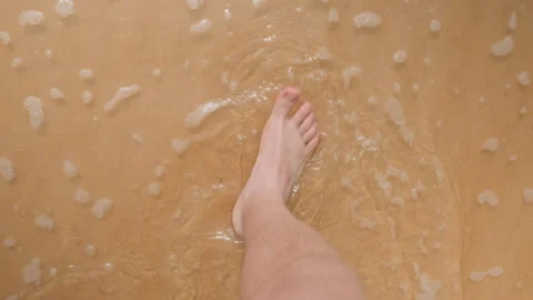 Walking barefoot on sandy shore. Unshoed steps on coastline near gentle sea Stock Footage 338092199
