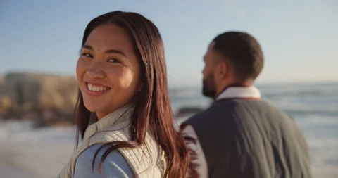 Walking, beach and face of couple holding hands by ocean for commitment, bonding Stockbeeldmateriaal 250223261