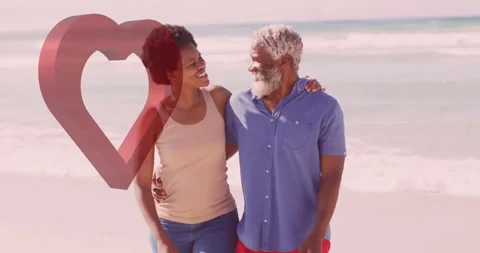 Walking on beach, elderly couple holding hands with heart animation overlay Stock Footage 305262224