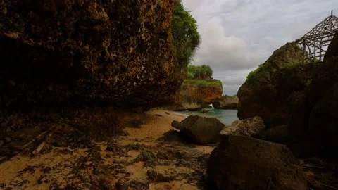 Walking on the beach with a huge cliff rocks Video stock 166373466